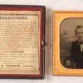 Lot 033 - Antique 1/6th Plate Ambrotype Photograph Of A Young Man With Mustache, Slight Smile, Photographed By I. Rehn, Philadelphia, With Note From Rehn In Case Regarding Care Of Ambrotypes, In Intact Leatherette Union Case, Note Loss To Black Varnish