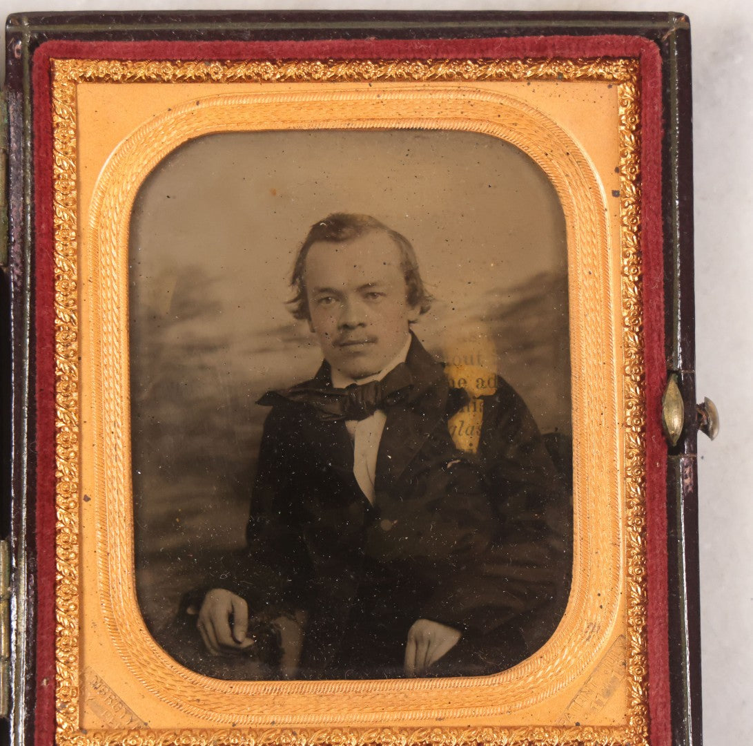 Lot 033 - Antique 1/6th Plate Ambrotype Photograph Of A Young Man With Mustache, Slight Smile, Photographed By I. Rehn, Philadelphia, With Note From Rehn In Case Regarding Care Of Ambrotypes, In Intact Leatherette Union Case, Note Loss To Black Varnish