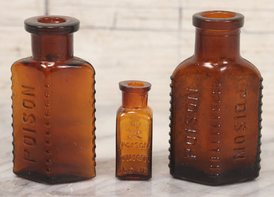 Lot 044 - Grouping Of Three Vintage Amber Glass Poison Bottles Including Tincture Of Iodine Bottle With Skull And Crossbones, Others With Embossed "Poison" Lettering, 2" and 3-5/8" Heights