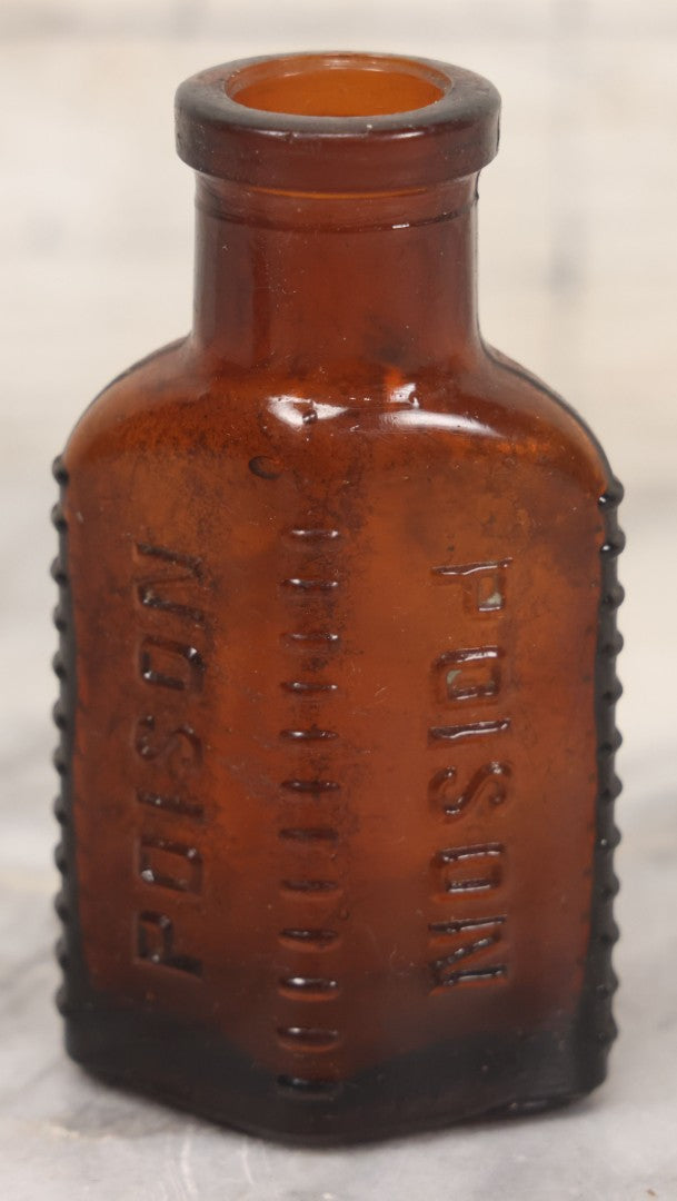 Lot 044 - Grouping Of Three Vintage Amber Glass Poison Bottles Including Tincture Of Iodine Bottle With Skull And Crossbones, Others With Embossed "Poison" Lettering, 2" and 3-5/8" Heights