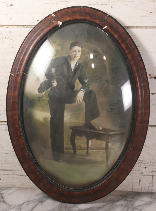 Lot 010 - Antique Hand Colored Solar Enlargement Photograph Of World War One Era United States Navy Sailor In Faux Wood Oval Bubble Glass Frame, 16-5/8" x 22-3/4"