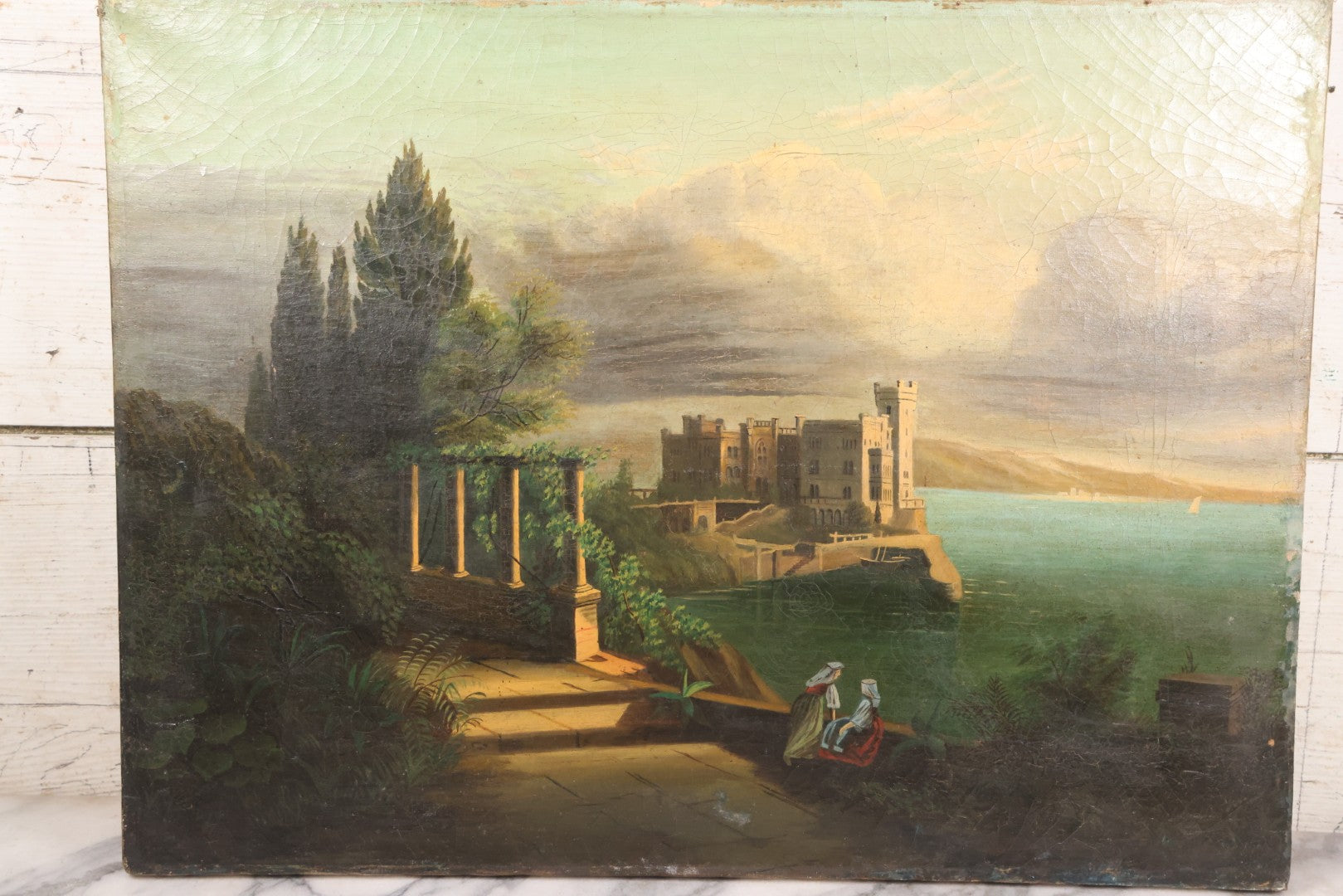 Lot 015 - Antique European Oil On Canvas Painting Landscape Scene Depicting Seaside Castle With Maidens Looking Toward The Coast From Stone Ruins, Mountains And Sailboats In The Distance, Cloudy Sky, Circa Early 19th Century, 24" x 18"
