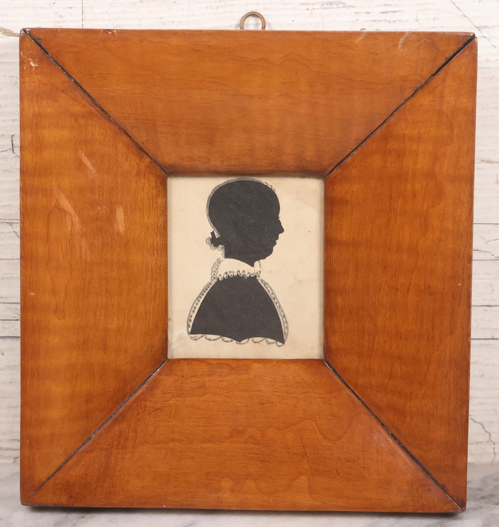 Lot 046 - Antique Folk Art Hand Cut Fabric Silhouette Of Young Girl With Added Pencil Details In Wide Tiger Maple Frame, 6-7/8" x 7-3/8"
