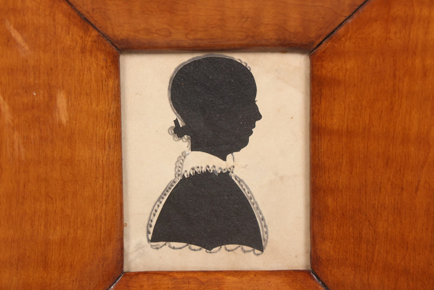 Lot 046 - Antique Folk Art Hand Cut Fabric Silhouette Of Young Girl With Added Pencil Details In Wide Tiger Maple Frame, 6-7/8" x 7-3/8"