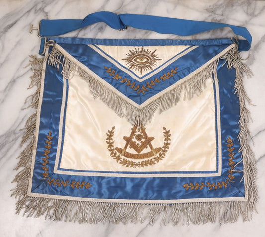 Lot 051 - Vintage Silk Embroidered Masonic Freemasons Fraternal Apron With All-Seeing Eye, Compass & Square Motifs, Blue & White Coloring, Gold Toned Metal Fringe And Embroidery, Manufactured By Harding Uniform & Regalia Co., Boston, Massachusetts