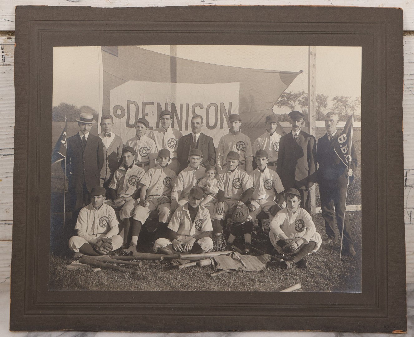 Lot 068 - Antique Boarded Photograph Of The Dennison Manufacturing Co. Baseball Team, Posing With Dennison Banner, Equipment, Circa 1915, Framingham, Massachusetts