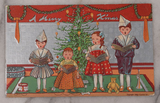 Lot 096 - Antique Embossed Christmas Postcard, "A Merry X'Mas" With Silver Coloring, Featuring Caroling Children, Toys, And Christmas Tree, With Embossed Christmas Seal Sticker On Verso, Postmarked 1909