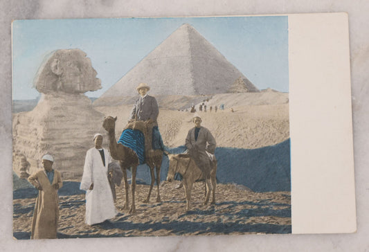 Lot 103 - Antique Photo Postcard Of Egypt Tourism With Added Color, Man On Camel With Guides In Front Of Pyramid Of Giza And Sphinx, Undivided Back, Circa 1907