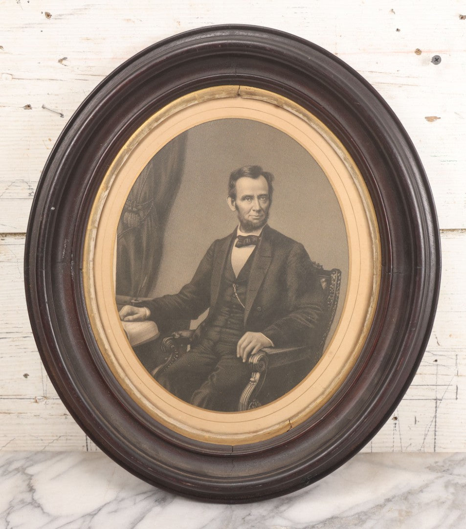 Lot 005 - Antique Engraving Print Of President Abraham Lincoln At Desk With Emancipation Proclamation, After George E. Perine, In Period Oval Frame With Original Glass And Wood Backing, Circa 1864, 14" x 16"