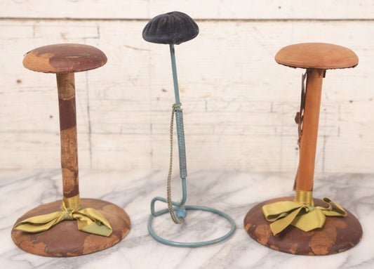 Lot 029 - Trio Of Vintage Hat Stands Including Two With Partial Fabric Coverings And Greenish-Yellow Ribbons, And One Blue Wire Stand With Felt Pillow
