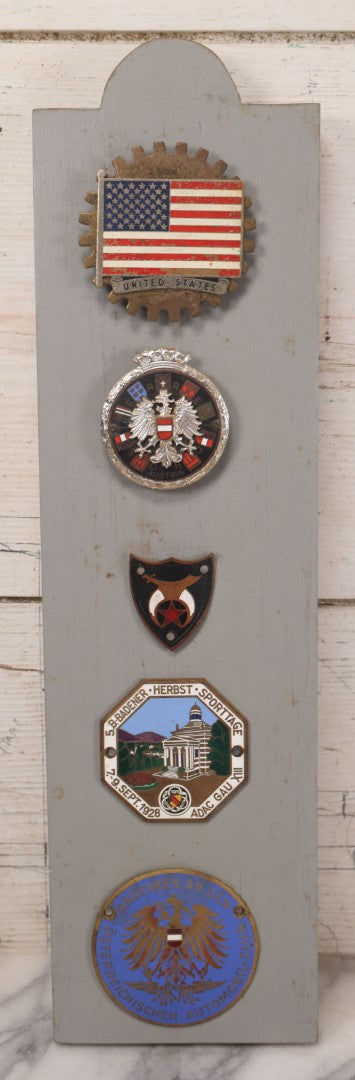 Lot 033 - Vintage Custom Cut Wooden Plaque With Five Metal Car Club Badges Including United States Flag, Austria Österreich, Shriners, A.D.A.C. 1928 Baden Sporttage, And Österreichischen Automobil-Club, 5-1/2" x 20-1/4"