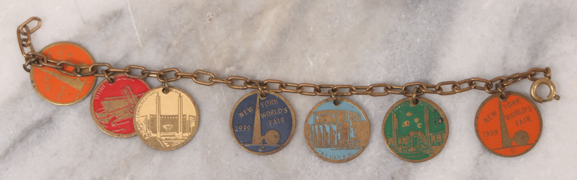 Lot 038 - Vintage Brass Chain Link Charm Bracelet With Six Enameled Souvenir Charms From The New York World's Fair 1939 Including Trylon And Perisphere And Landmark Buildings, 7" Length
