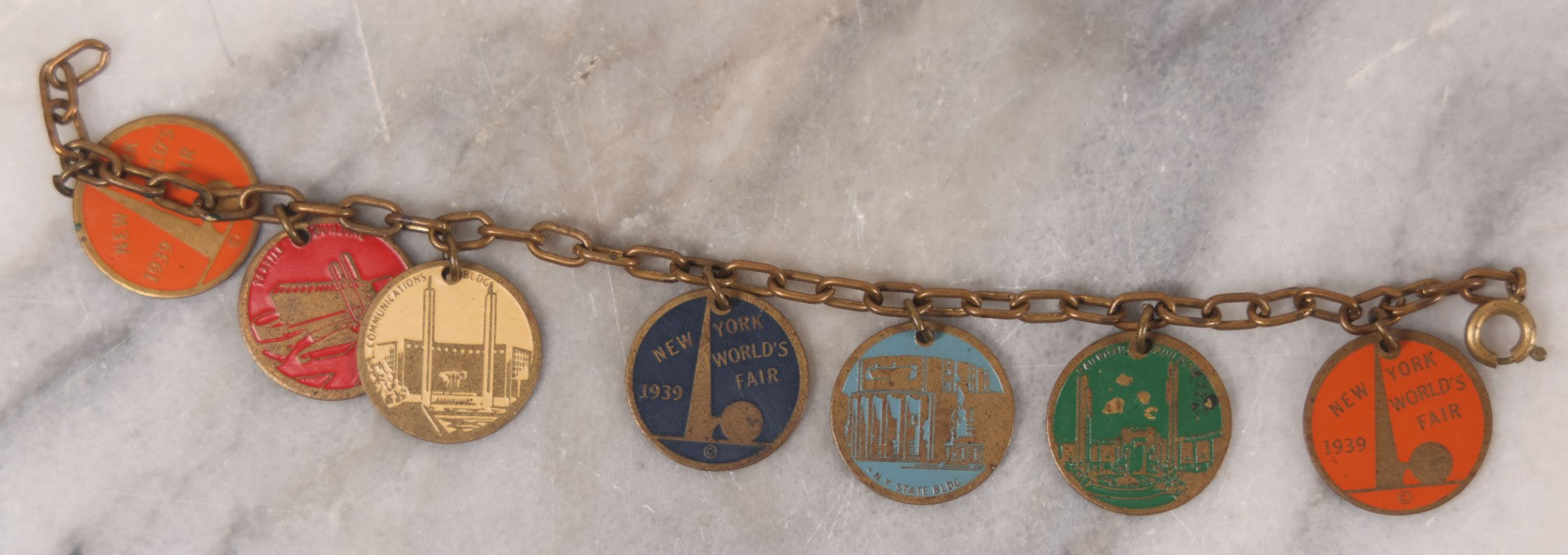 Lot 038 - Vintage Brass Chain Link Charm Bracelet With Six Enameled Souvenir Charms From The New York World's Fair 1939 Including Trylon And Perisphere And Landmark Buildings, 7" Length