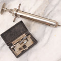 Lot 045 - Antique “Reliable” Brand Syringe No. 3 With Metal Body And Glass Center Tube, With Box Of Vintage B.D. Needles