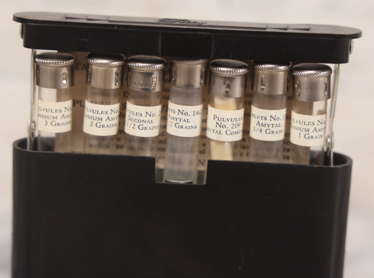 Lot 047 - Vintage Eli Lilly Bakelite Vial Holder With Seven Glass Vials With Paper Labels Including Amytal Compounds, With Paper Insert