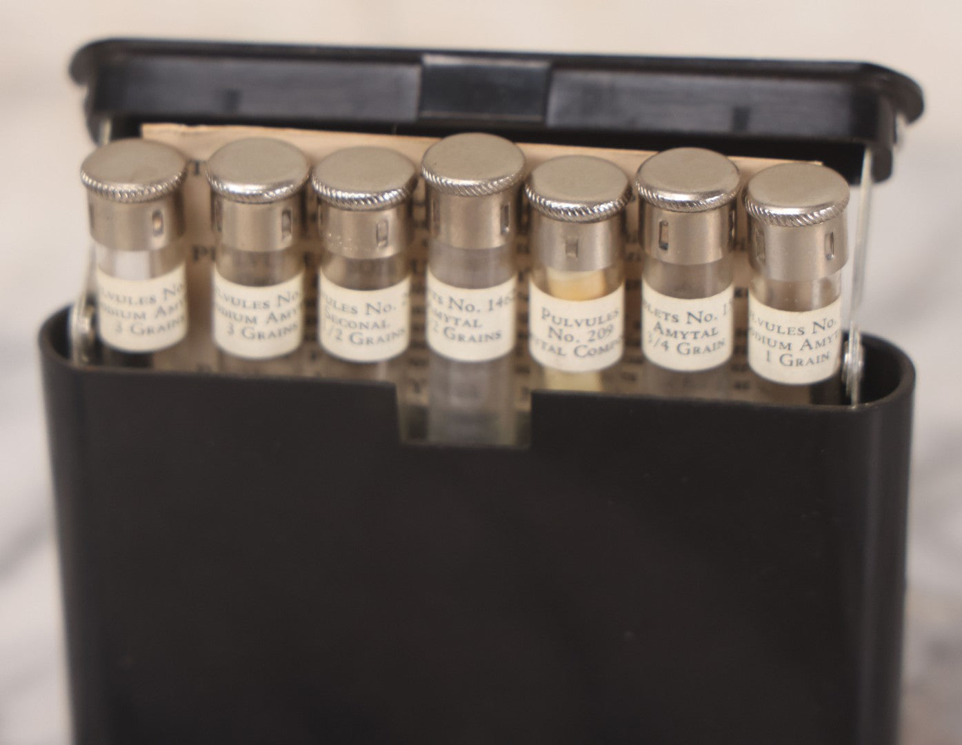 Lot 047 - Vintage Eli Lilly Bakelite Vial Holder With Seven Glass Vials With Paper Labels Including Amytal Compounds, With Paper Insert