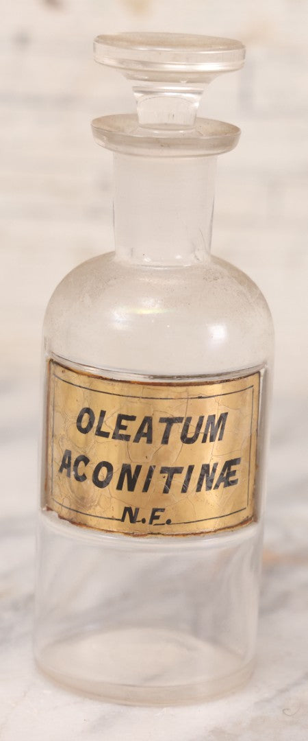 Lot 057 - Antique Whitall Tatum Co. Clear Glass Apothecary Bottle With Stopper And Reverse Painted Label “Oleatum Aconitinae N.F.” Small Size, 5-1/2" H