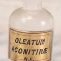 Lot 057 - Antique Whitall Tatum Co. Clear Glass Apothecary Bottle With Stopper And Reverse Painted Label “Oleatum Aconitinae N.F.” Small Size, 5-1/2" H