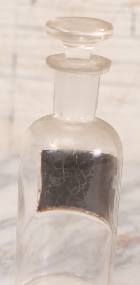 Lot 057 - Antique Whitall Tatum Co. Clear Glass Apothecary Bottle With Stopper And Reverse Painted Label “Oleatum Aconitinae N.F.” Small Size, 5-1/2" H