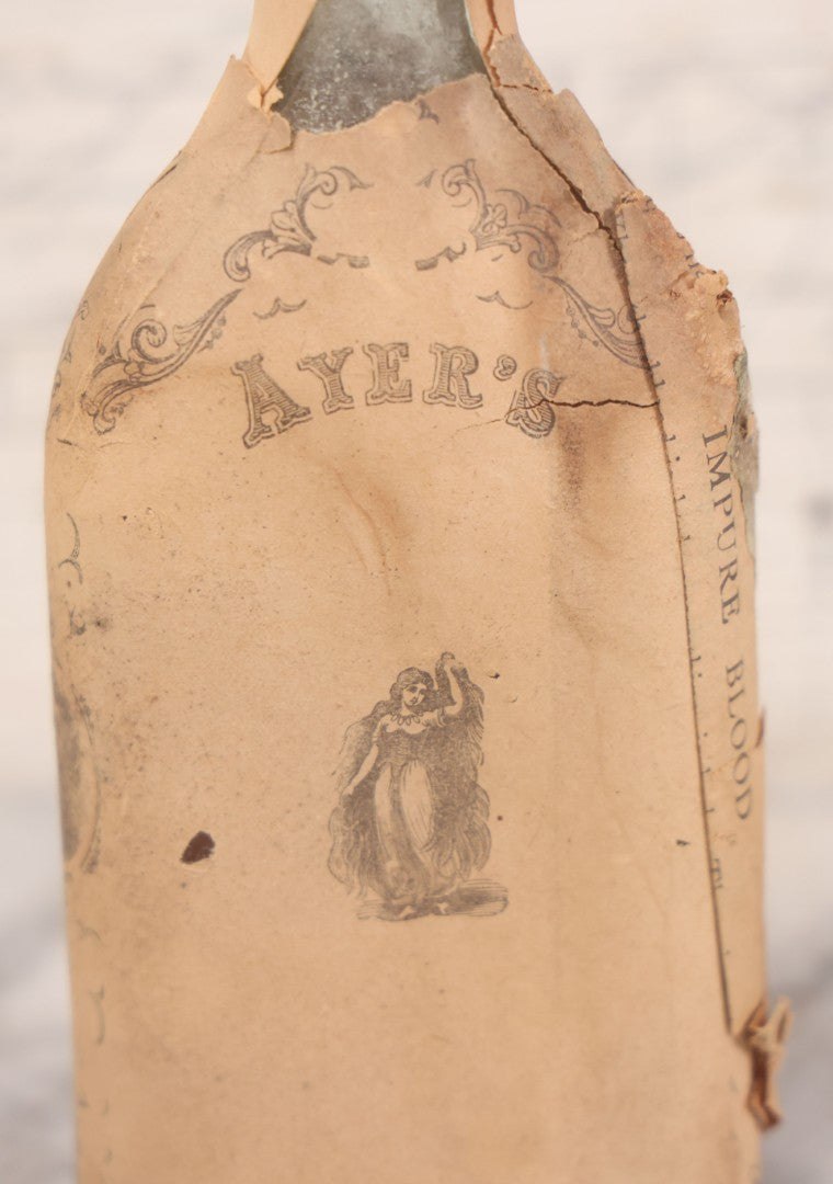 Lot 059 - Antique Ayer's Clear Glass Bottle With Partial Paper Label Wrapper And Embossed Base, 7-1/2" H