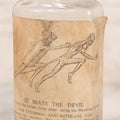 Lot 060 - Antique Clear Glass Bottle With Paper Label “It Beats The Devil” Showing Devil Race Graphics, Arthur N. Roe, Branchville, New Jersey, 5-1/2" H