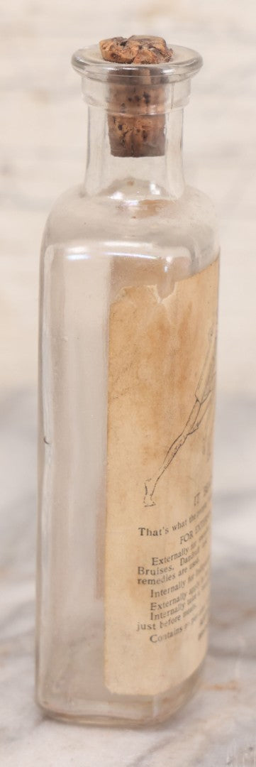 Lot 060 - Antique Clear Glass Bottle With Paper Label “It Beats The Devil” Showing Devil Race Graphics, Arthur N. Roe, Branchville, New Jersey, 5-1/2" H