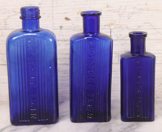 Lot 064 - Grouping Of Three Antique Cobalt Blue Glass Poison Bottles With Embossed Lettering “Not To Be Taken,” Rectangular Form With Vertical Poison Ribs, Three Sizes