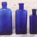 Lot 064 - Grouping Of Three Antique Cobalt Blue Glass Poison Bottles With Embossed Lettering “Not To Be Taken,” Rectangular Form With Vertical Poison Ribs, Three Sizes