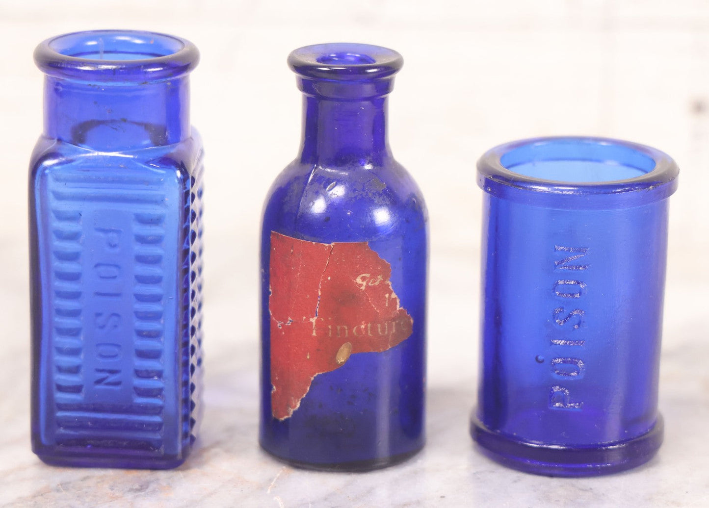 Lot 066 - Grouping Of Three Antique Cobalt Blue Glass Poison Bottles, Including Embossed “Poison” With Horizontal Ribs, Embossed “Wyeth Poison” Without Ribs, And Whitall Tatum Co. Bottle With Partial Paper Label