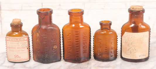 Lot 068 - Grouping Of Five Antique Amber Glass Poison Bottles With Horizontal Poison Ribs, Including Faded Eli Lilly & Co. Label And Kern Pharmacy Label, Flushing, New York, One With Eli Lilly & Co. Atropine Sulphate Label, And Three Without Labels