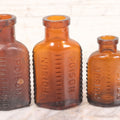 Lot 068 - Grouping Of Five Antique Amber Glass Poison Bottles With Horizontal Poison Ribs, Including Faded Eli Lilly & Co. Label And Kern Pharmacy Label, Flushing, New York, One With Eli Lilly & Co. Atropine Sulphate Label, And Three Without Labels
