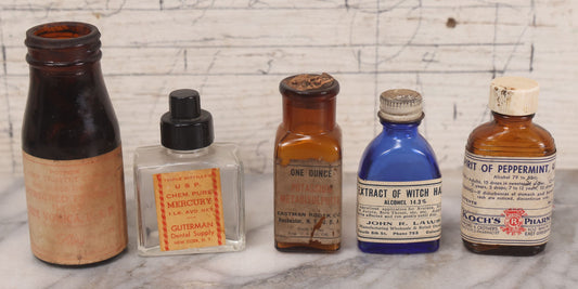 Lot 073 - Grouping Of Five Antique Bottles With Paper Labels Including Witch Hazel, John Laws, Columbus M.S., Spirit Of Peppermint, Koch's Pharm., Greenwich, R.I., Potassium Metabisulphate, Kodak, Mercury, Guterman Dental, N.Y., & Nux Vomica