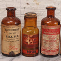 Lot 074 - Grouping Of Five Antique Amber Glass Bottles Including Digitalis From Eli Lilly & Co., Indianapolis, Phytolacca From Parke, Davis & Co., Detroit, De Mercure Codex 1908, And Kola From Eli Lilly & Co., And Others