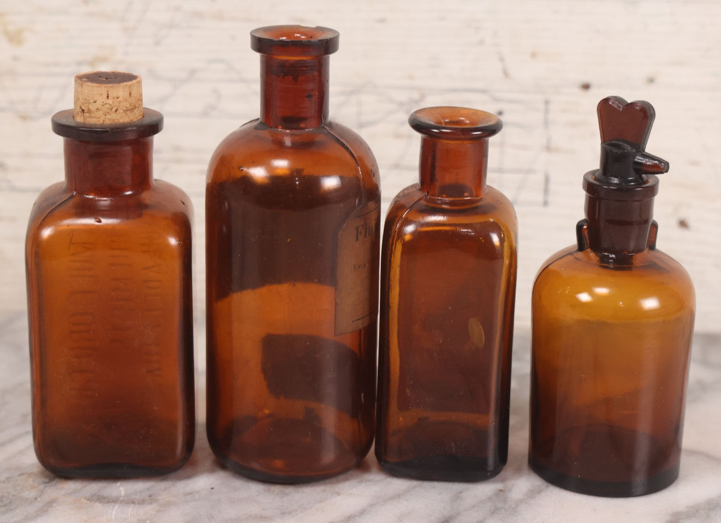 Lot 075 - Grouping Of Four Antique Amber Glass Bottles Including Cramp Bark From Sharp & Dohme, Baltimore, Sanguinaria From John Wyeth & Brother, Philadelphia, H.K. Mulford Co., Philadelphia, And One Unmarked With Stopper