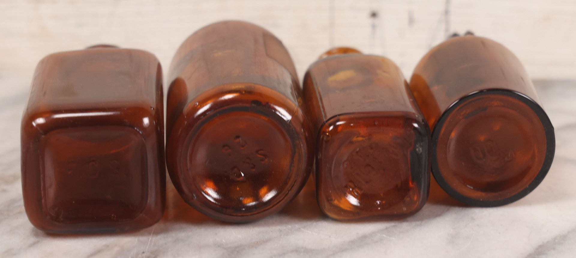 Lot 075 - Grouping Of Four Antique Amber Glass Bottles Including Cramp Bark From Sharp & Dohme, Baltimore, Sanguinaria From John Wyeth & Brother, Philadelphia, H.K. Mulford Co., Philadelphia, And One Unmarked With Stopper