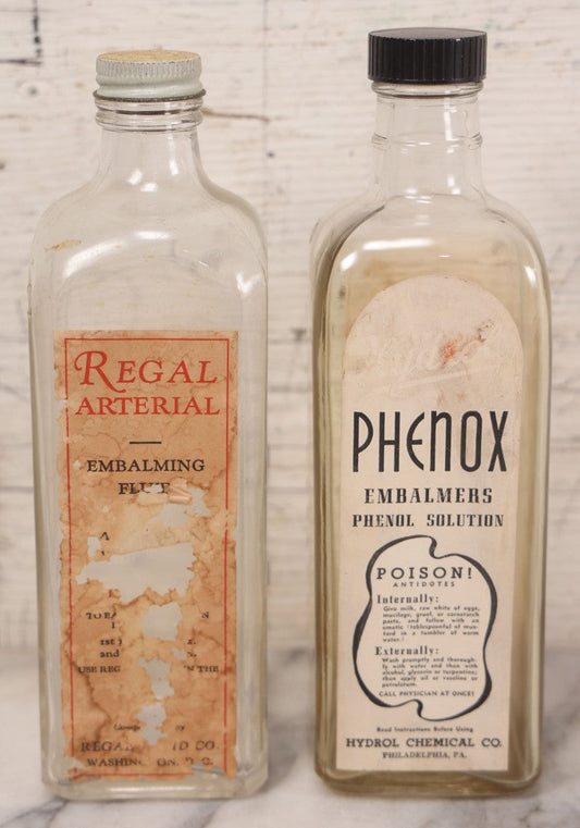 Lot 077 - Pair Of Vintage Clear Glass Embalming Fluid Bottles With Paper Labels And Caps Including Regal Arterial From Regal Fluid Co., Washington, D.C., And Hydrol Phenox From Hydrol Chemical Co., Philadelphia
