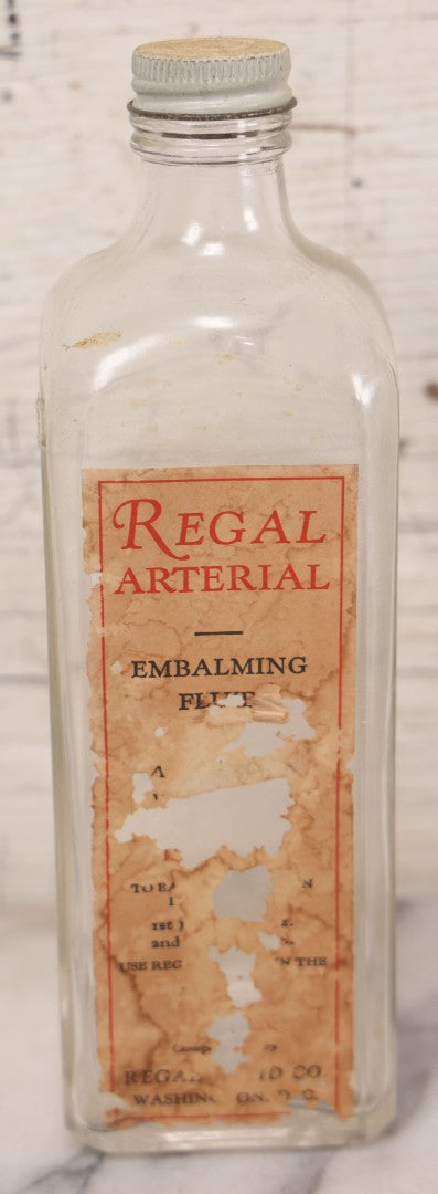 Lot 077 - Pair Of Vintage Clear Glass Embalming Fluid Bottles With Paper Labels And Caps Including Regal Arterial From Regal Fluid Co., Washington, D.C., And Hydrol Phenox From Hydrol Chemical Co., Philadelphia