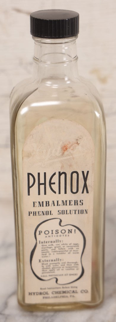Lot 077 - Pair Of Vintage Clear Glass Embalming Fluid Bottles With Paper Labels And Caps Including Regal Arterial From Regal Fluid Co., Washington, D.C., And Hydrol Phenox From Hydrol Chemical Co., Philadelphia