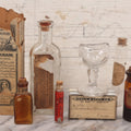 Lot 078 - Grouping Of Eight Antique Apothecary Items Including Amber Bottle With "G.C. Oval" Label, Balsam Bottle, Hall & Lyon Co. Pill Box, Carter's Laxative Vial, Wheeler Pharmacist Vial, Sharon, M.A., Glycerine Jelly Bottle, & John Bull Eye Wash Cup