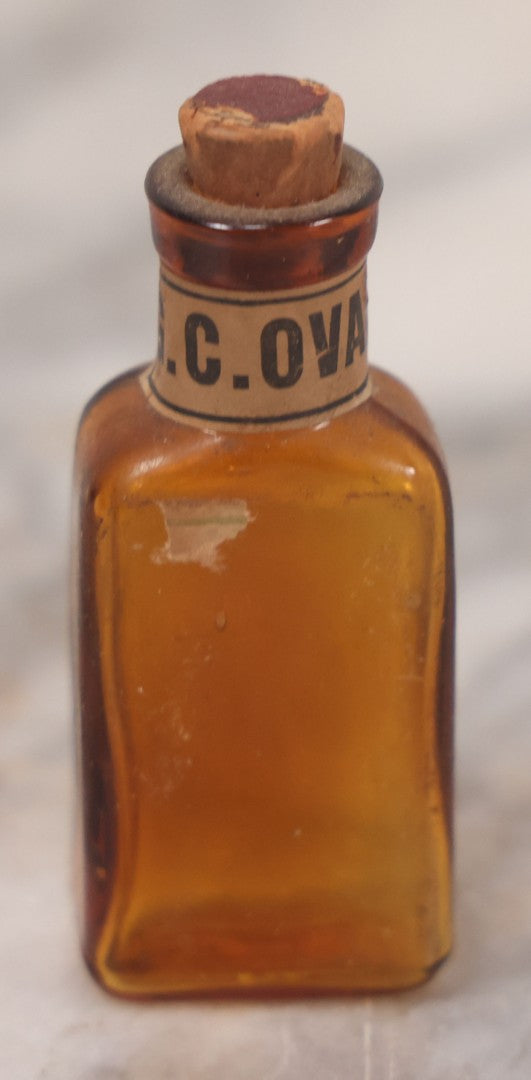 Lot 078 - Grouping Of Eight Antique Apothecary Items Including Amber Bottle With "G.C. Oval" Label, Balsam Bottle, Hall & Lyon Co. Pill Box, Carter's Laxative Vial, Wheeler Pharmacist Vial, Sharon, M.A., Glycerine Jelly Bottle, & John Bull Eye Wash Cup