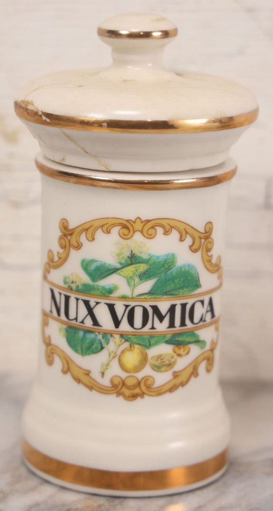 Lot 084 - Reproduction Fantasy Apothecary Jar With Lid Marked “Nux Vomica” White Opaque Pottery With Gold Painted Lines, Mid-20th Century, Bottom Marked Made In U.S.A., Note Broken And Repaired Lid, 7-5/8" H