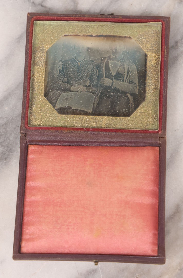 Lot 093 - Antique 1/6th Plate Daguerreotype Photograph Of Couple In Full Leatherette Case, Gold Painted Border, Faded Red Cushion, Anthony, Clark & Co. Label On Verso, Note Damage To Case