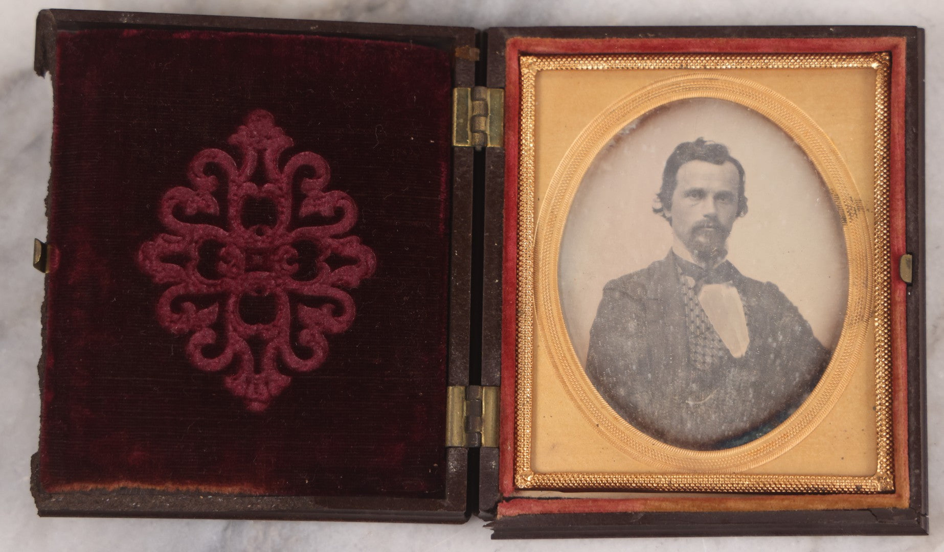 Lot 094 - Antique 1/6th Plate Daguerreotype Photograph Of Man In Full Thermoplastic Case With Abstract Floral Design, Brass Mat, Dark Red Cushion, Heavily Speckled Surface Of Photograph, Note Damage To Case