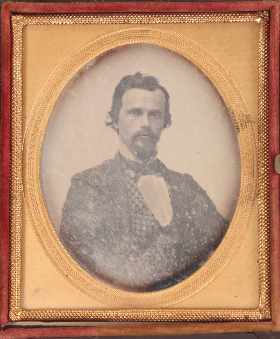 Lot 094 - Antique 1/6th Plate Daguerreotype Photograph Of Man In Full Thermoplastic Case With Abstract Floral Design, Brass Mat, Dark Red Cushion, Heavily Speckled Surface Of Photograph, Note Damage To Case