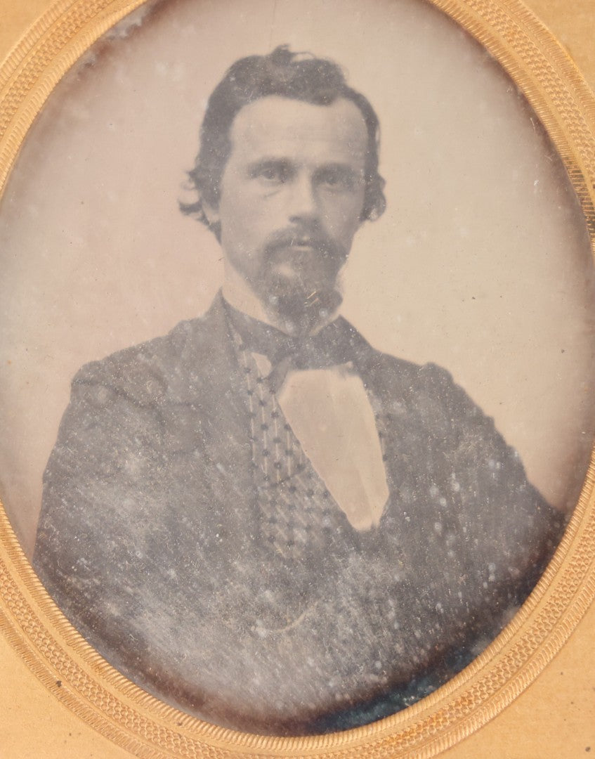 Lot 094 - Antique 1/6th Plate Daguerreotype Photograph Of Man In Full Thermoplastic Case With Abstract Floral Design, Brass Mat, Dark Red Cushion, Heavily Speckled Surface Of Photograph, Note Damage To Case