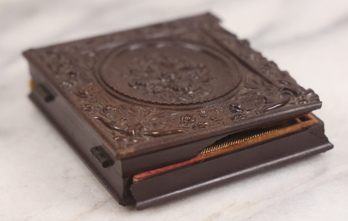 Lot 094 - Antique 1/6th Plate Daguerreotype Photograph Of Man In Full Thermoplastic Case With Abstract Floral Design, Brass Mat, Dark Red Cushion, Heavily Speckled Surface Of Photograph, Note Damage To Case