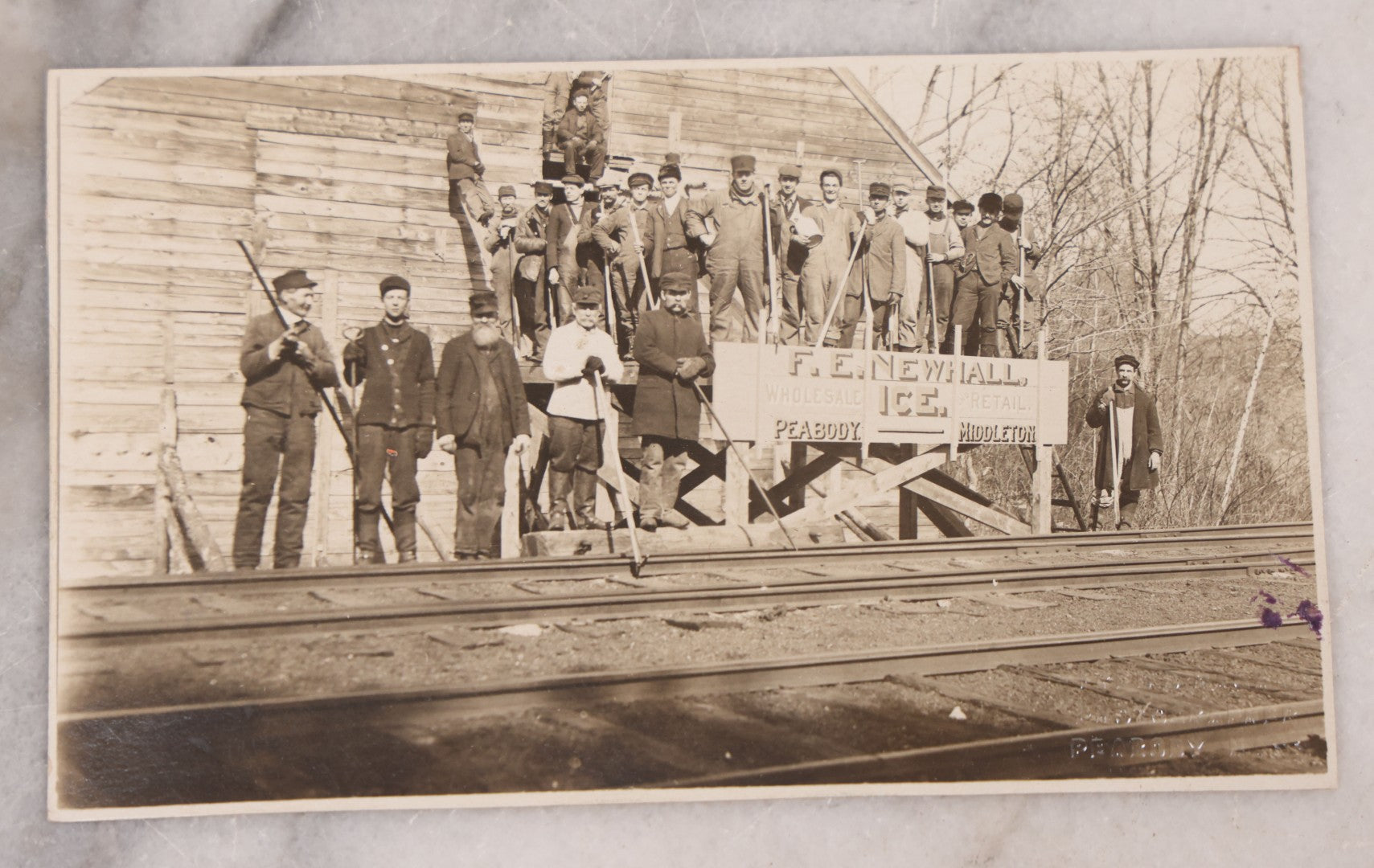 Lot 100 - Pair Of Antique Real Photo Postcards R.P.P.C., Including Photo Of Group Of Workers Posing With R.E. Newhall, Wholesale And Retail Ice Sign On Railroad Tracks, And Photo Of Two Men Posing At A Post Office Shack With Sign "Don't Call On Sunday"