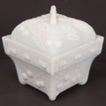 Lot 135 - Antique Milk Glass Covered Dish With Embossed Fruit And Leaf Design On Four Feet, Note Chipped Corner