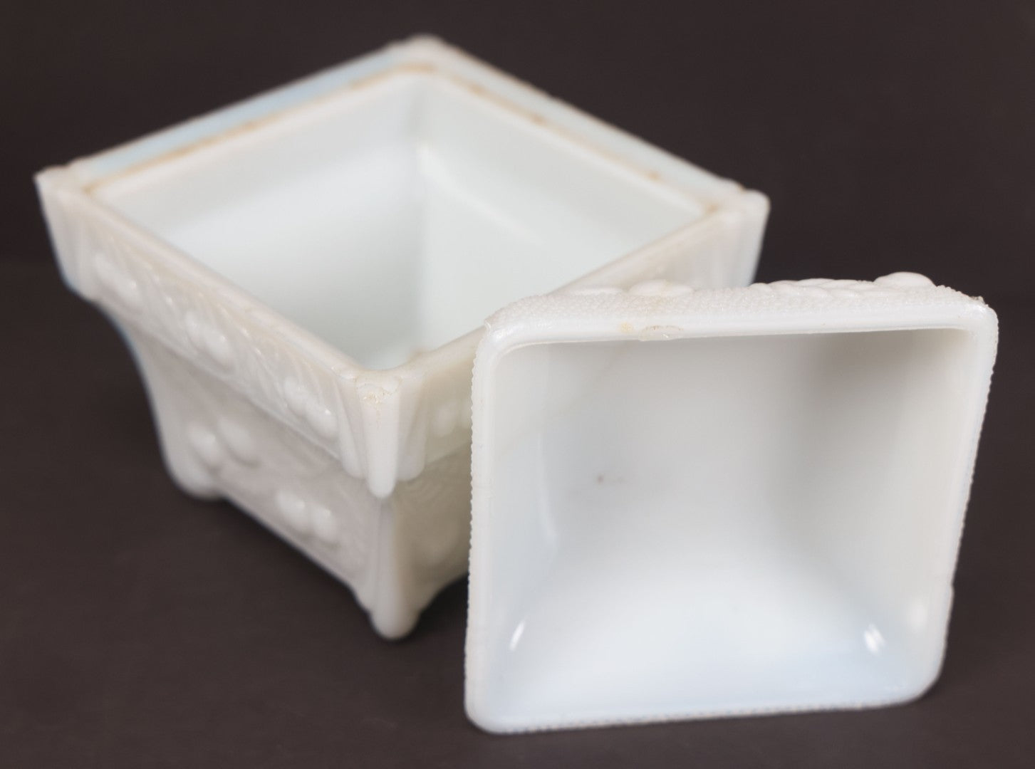 Lot 135 - Antique Milk Glass Covered Dish With Embossed Fruit And Leaf Design On Four Feet, Note Chipped Corner