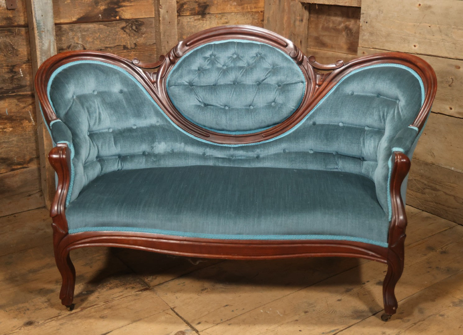 Antique Victorian Carved Walnut Settee With Tufted Blue Upholstery And Casters